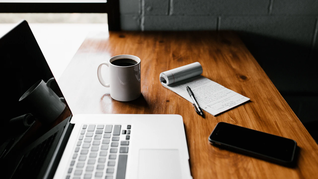 Laptop, mug and phone on a desk