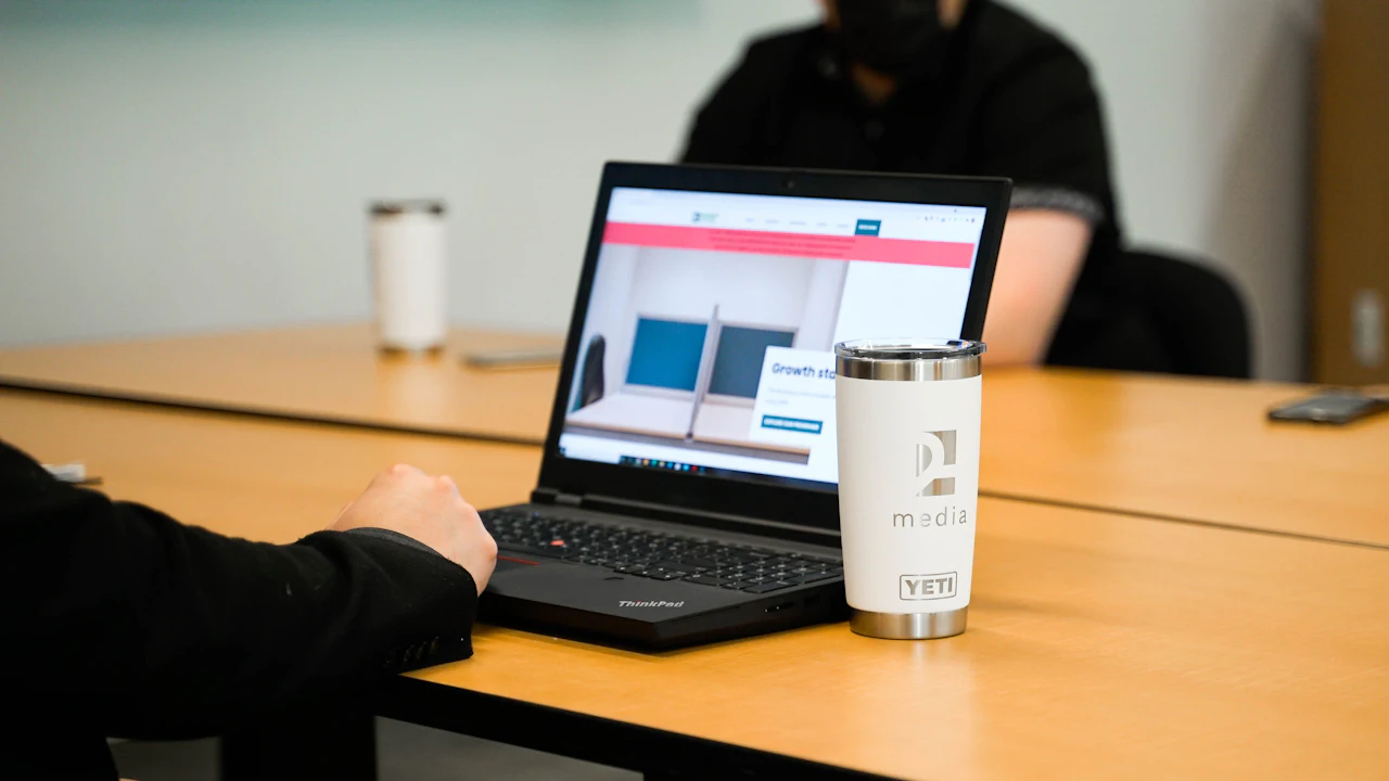 A laptop on a wooden meeting table