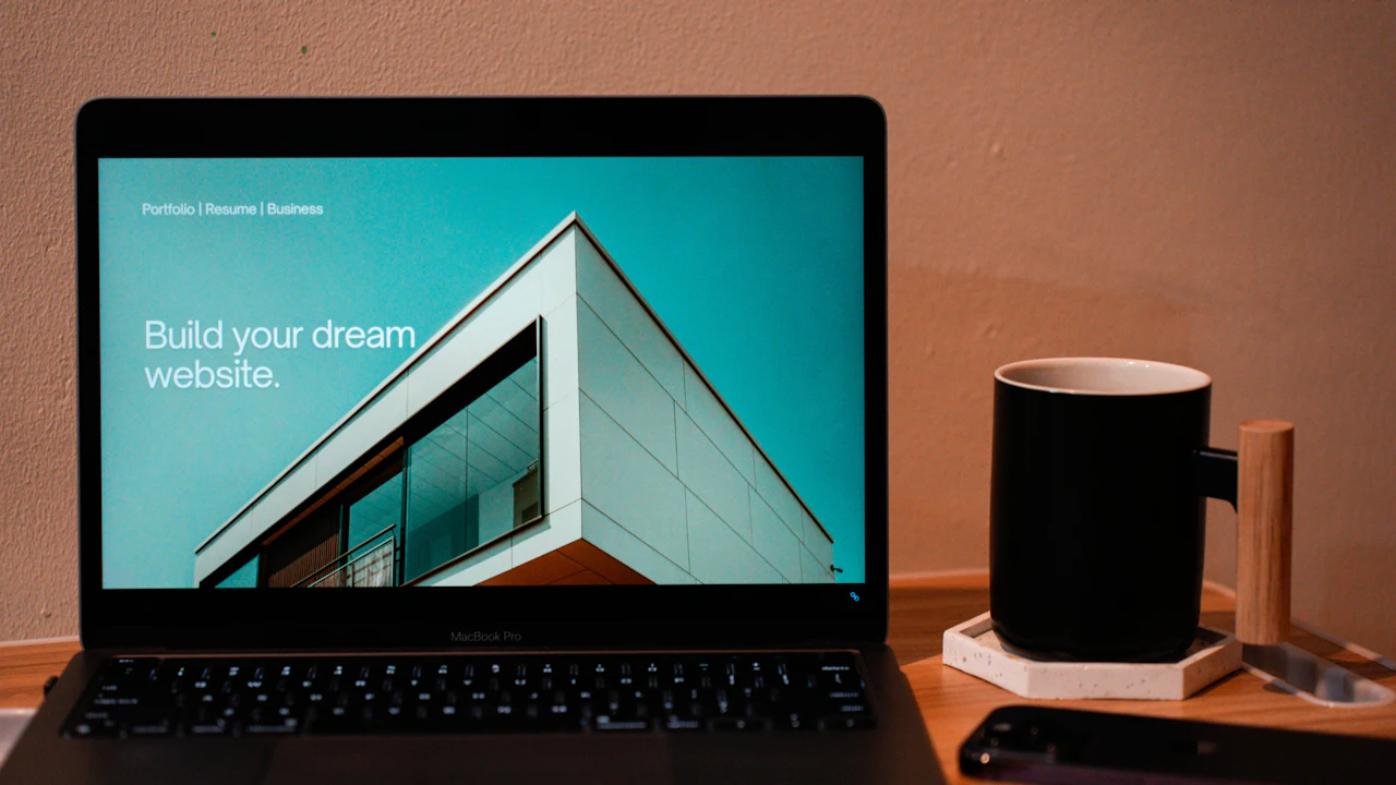 A laptop showing a website on a wooden desk